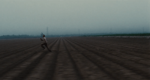 man running across a dry field
