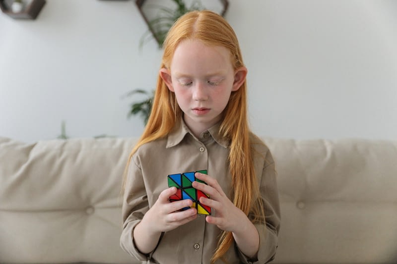 girl sits and play with a cube
