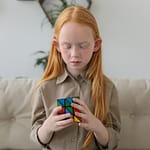 girl sits and play with a cube